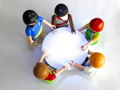 Foto: Mennesker i samtale rundt et bord- illustrerer familiesamt med alle i familien inkludert